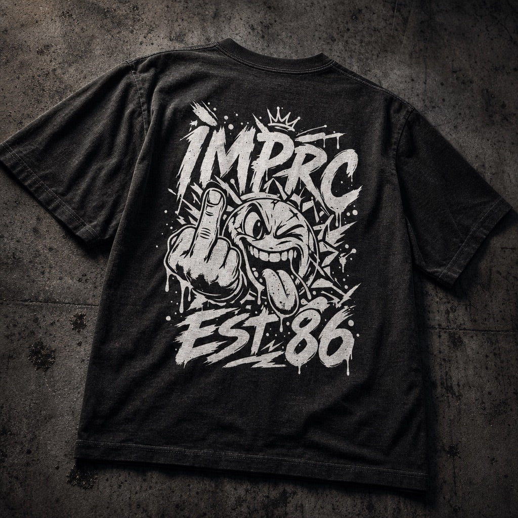 A black graphic t-shirt laid flat on a textured dark gray concrete background. The back of the shirt features a large white spray-paint style graphic with the text 'IMPRC EST.