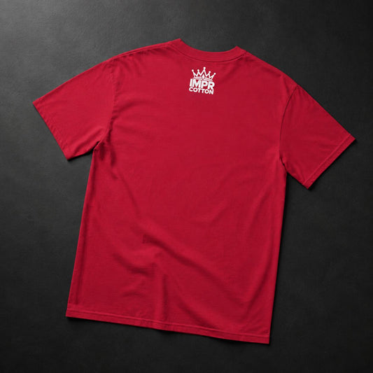 A red short-sleeve t-shirt laid flat on a dark textured background, showing a white crown and 'MPR COTTON' logo printed on the upper back.