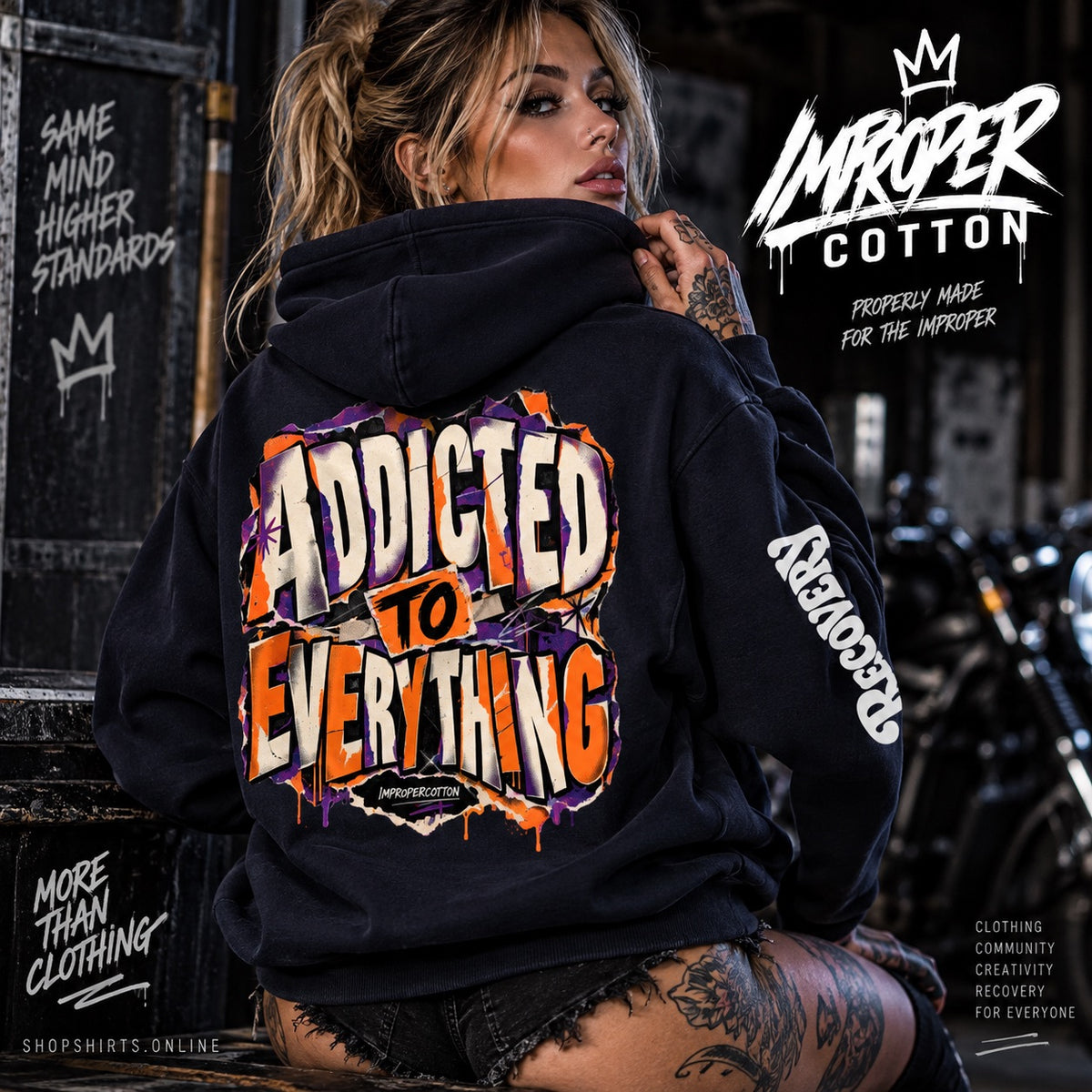 A woman wearing a black hoodie with a large colorful graphic on the back reading 'ADDICTED TO EVERYTHING' and white text on the sleeve, posed in a gritty urban setting with bikes and dark walls in the background. Branding text for Improper Cotton appears in the top right.