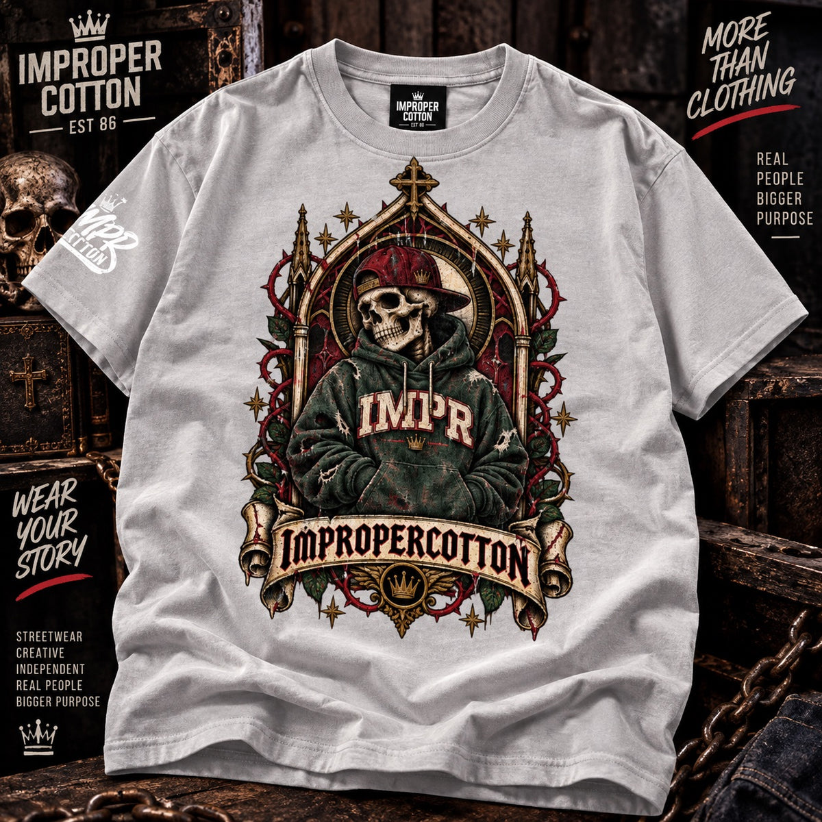 A light gray short-sleeve t-shirt with a detailed gothic-style graphic of a skeleton wearing a red cap and green hoodie, set against a dark ornate background. The shirt features 'IMPROPER COTTON' branding on the neck label and sleeve, with promotional text overlays on the sides.