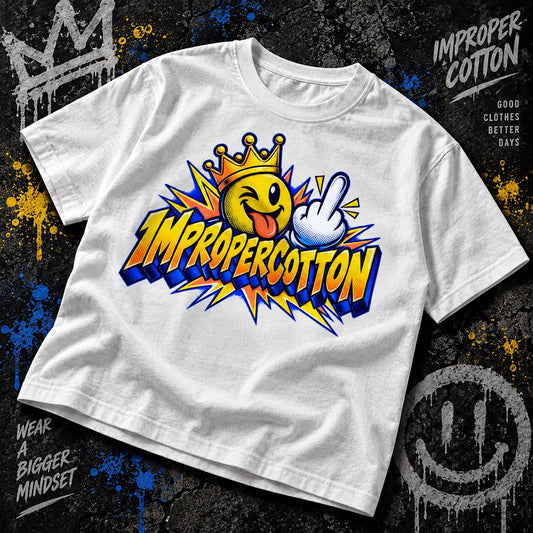 A white short-sleeve graphic T-shirt laid flat on a dark textured background with paint splatters. The shirt features a large colorful front print with a smiling face in a crown, a hand gesture, and the text 'IMPROPERCOTTON'.