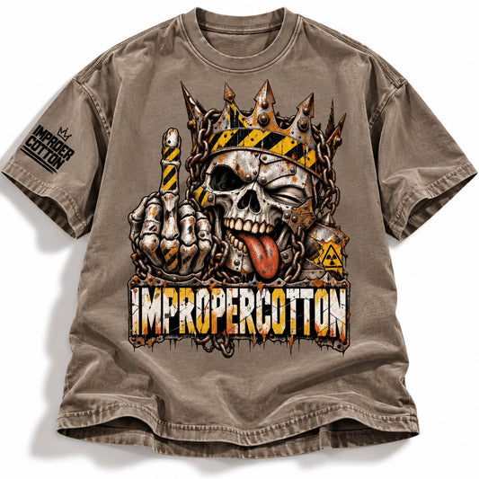 A brown short-sleeve graphic t-shirt featuring a skull wearing a spiked crown and holding up a middle finger, with the text 'IMPROPERCOTTON' printed below. The shirt is laid flat against a white background.