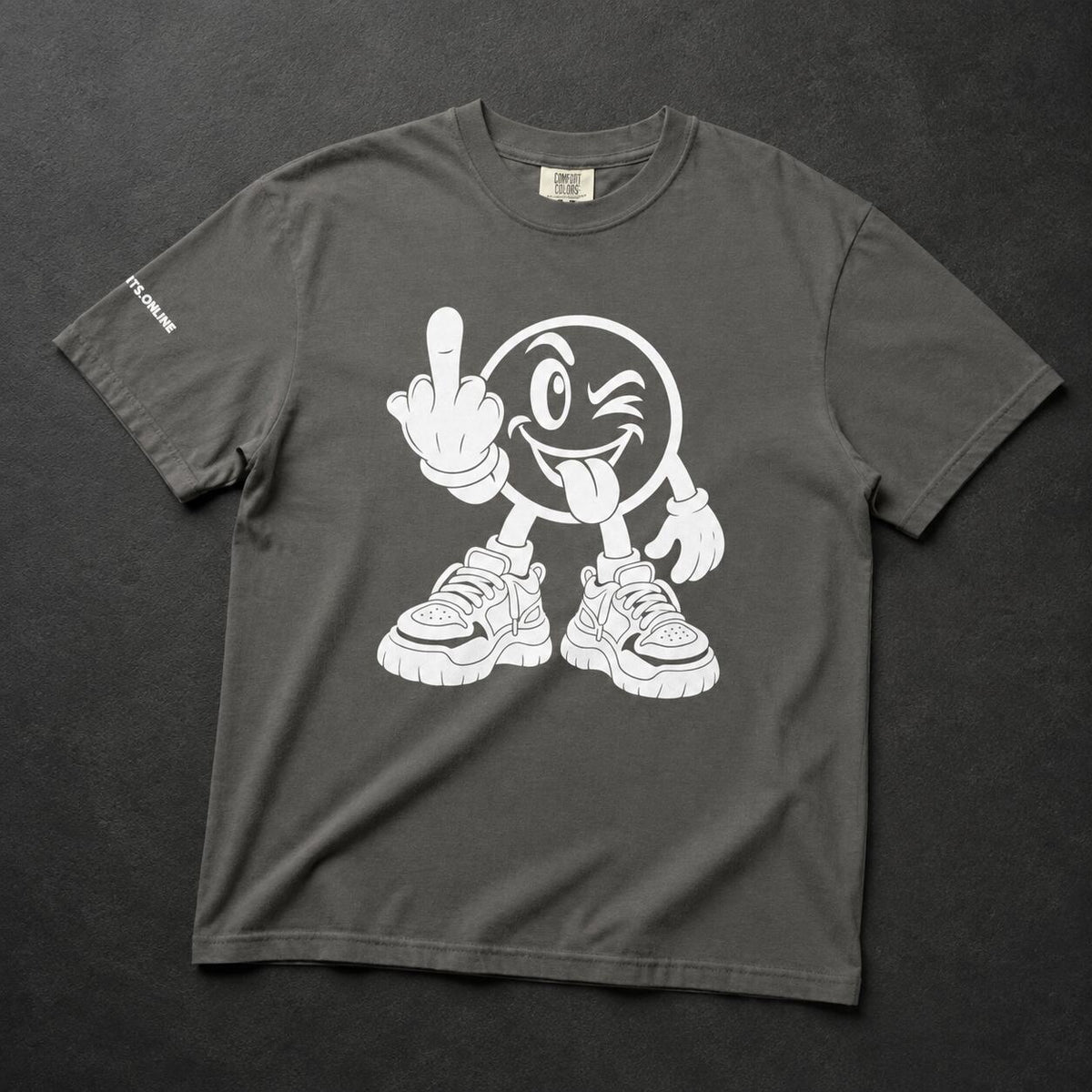 A dark gray crewneck t-shirt featuring a white graphic of a winking cartoon face sticking out its tongue and wearing sneakers, laid flat on a dark textured background.