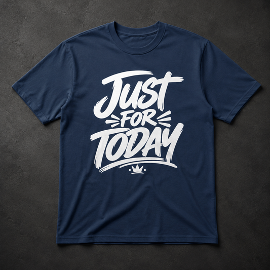 A navy blue short-sleeve t-shirt with a white graphic print reading 'Just FOR TODAY' and a small crown underneath, laid flat on a dark textured background.