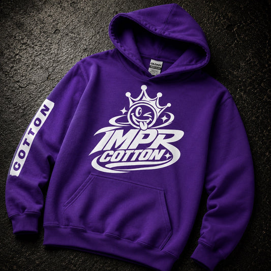 A purple pullover hoodie with a white graphic on the chest reading 'IMPR COTTON' beneath a crown and eye logo, plus a vertical 'COTTON' sleeve print, laid flat on a dark textured surface.