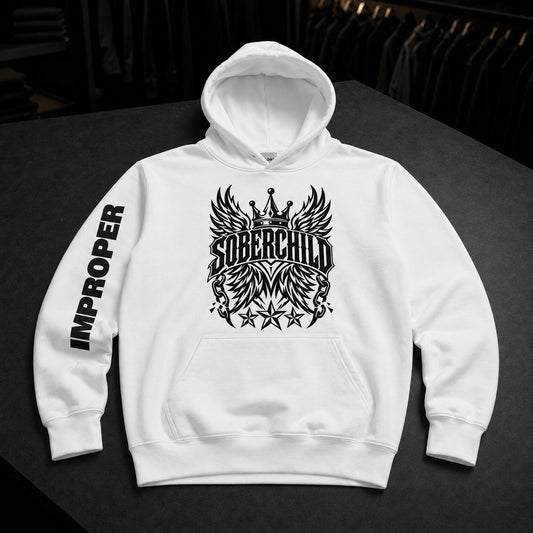 A white pullover hoodie laid flat on a dark surface, featuring a large black winged crown graphic with the word 'SOBERCHILD' across the chest and 'IMPROPER' printed vertically on one sleeve.