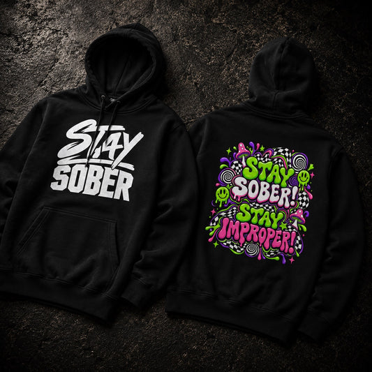 Two black hoodies laid flat on a dark textured surface, showing the front and back designs. The front hoodie has a large white 'Stay Sober' graphic, and the back hoodie has a colorful psychedelic graphic with the words 'Stay Sober! Stay Improper!' in green, pink, and purple.