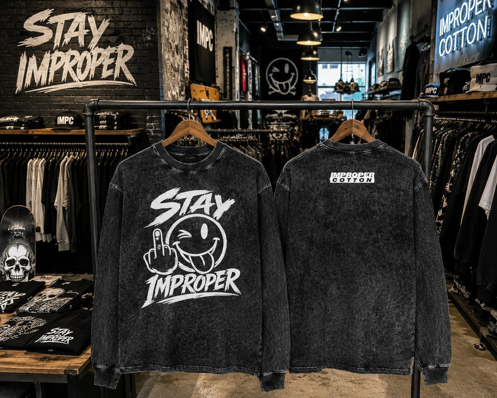 Two black acid-wash graphic crewneck sweatshirts from Stay Improper, shown from the front and back on wooden hangers in a retail store setting.