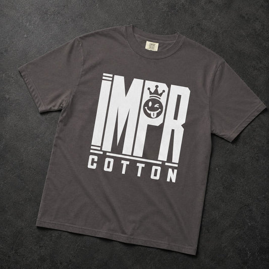 A dark gray crewneck t-shirt with a bold white graphic print reading 'IMPR COTTON' and a crown motif, laid flat on a dark textured background.