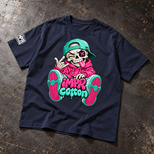 A navy blue graphic t-shirt laid flat on a textured, dark gray concrete-like surface. The shirt features a large cartoon graphic of a skeleton wearing a pink hoodie and a green cap, with the text 'IMP Cotton' in pink and green.