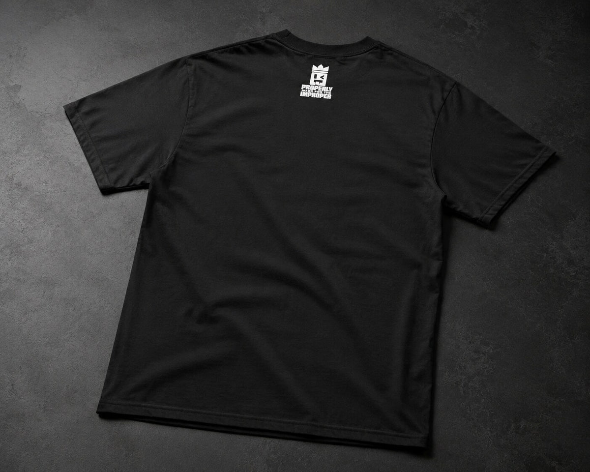 A black short-sleeve t-shirt laid flat on a dark textured gray background, featuring a small white graphic logo printed on the upper back.