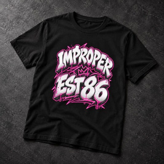 A black short-sleeve t-shirt laid flat on a dark textured background, featuring a large graffiti-style graphic on the front that reads 'IMPROPER EST 86' in white with bright pink outlines.