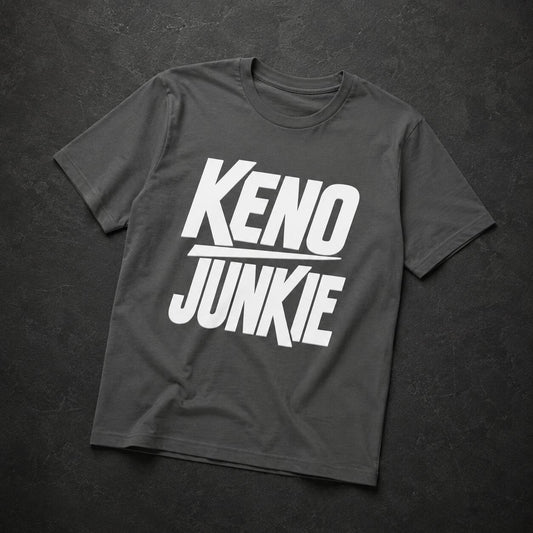 A dark gray crewneck t-shirt with a bold white graphic reading 'KENO JUNKIE' across the chest, laid flat on a dark textured background.