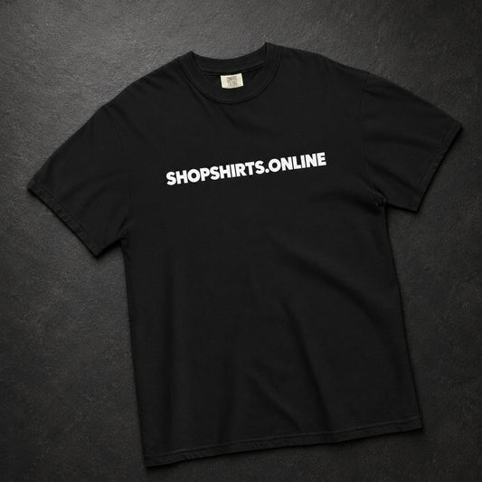 A black short-sleeve crewneck t-shirt with the text 'SHOPSHIRTS.ONLINE' printed in white across the chest, laid flat on a dark textured background.
