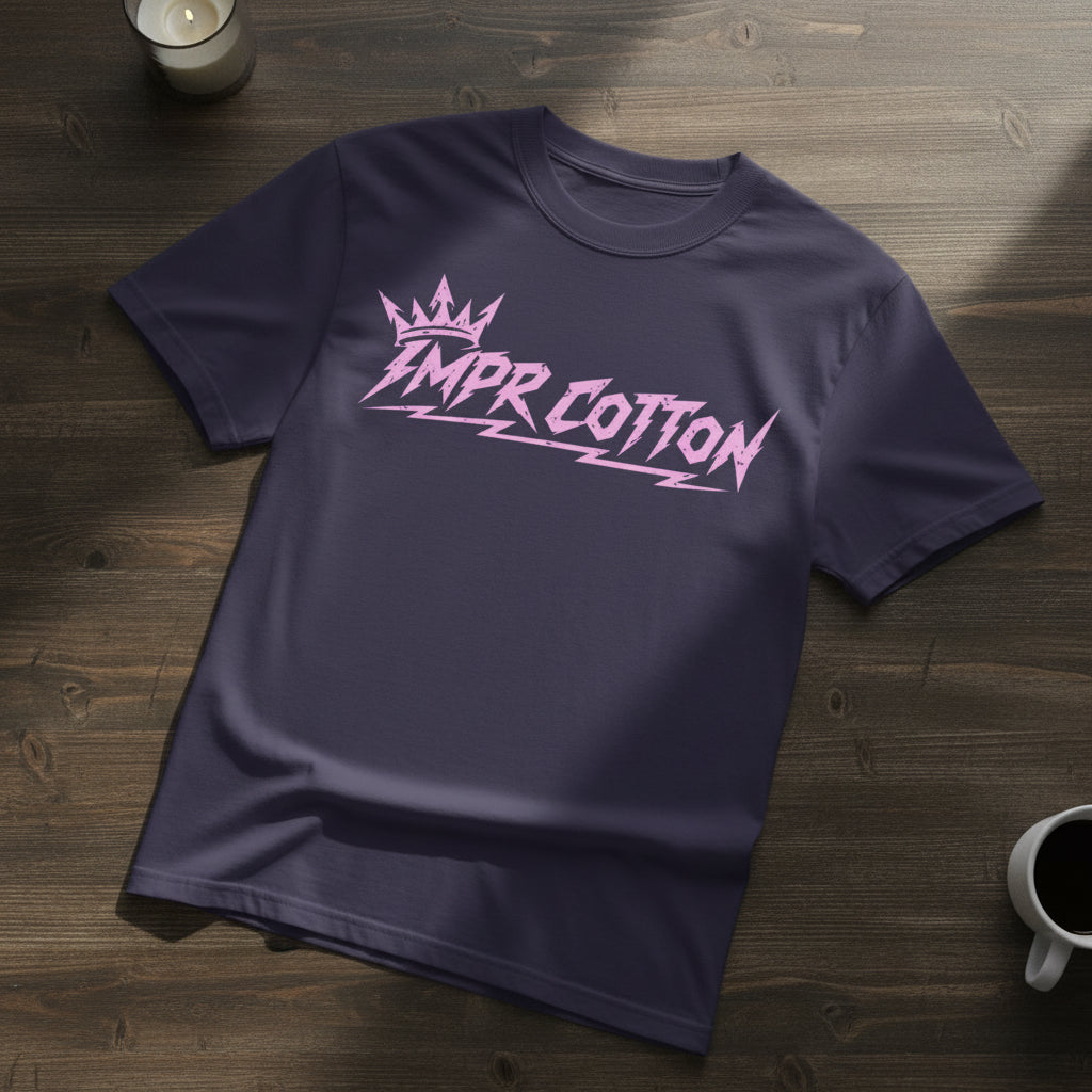 A dark purple short-sleeve t-shirt with a pink graphic on the chest reading 'IMPR COTTON' in a stylized font under a small crown, displayed on a clean white background.